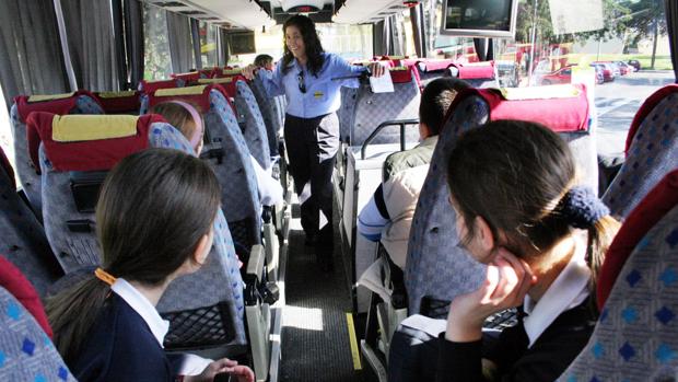 Alumnos atienden a las explicaciones de la conductora de un autobús escolar