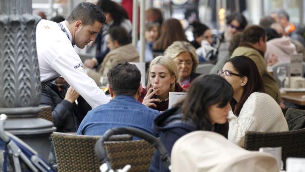 Un camarero atiende a unos clientes en una terraza