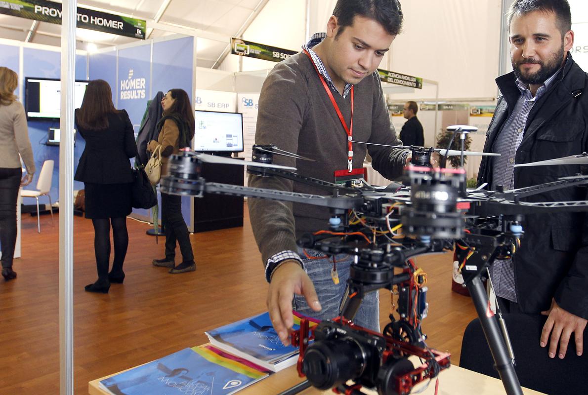 Dos participantes en Fimart 2014 contemplan un dron en uno de los expositores