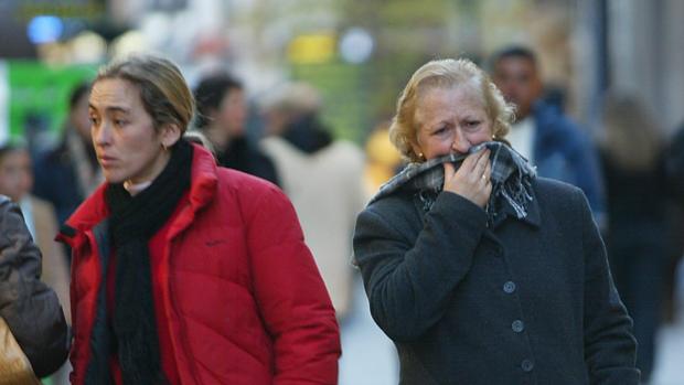 Algunos viandantes se protegen del frío con bufandas