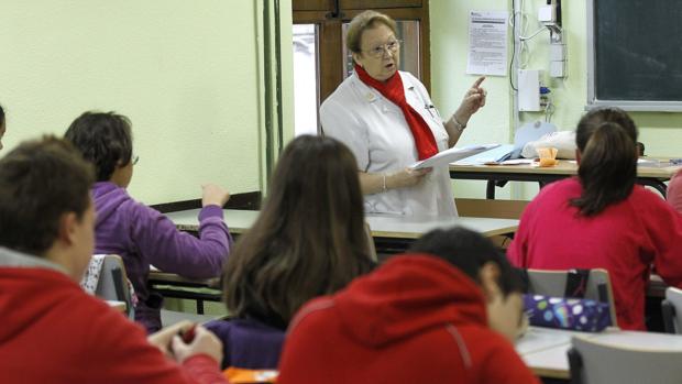 Una profesora se dirige a un grupo de alumnos en una clase