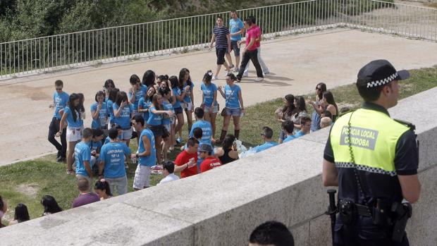 Un policía local vigila el ya clásico «macrobotellón» de la Feria