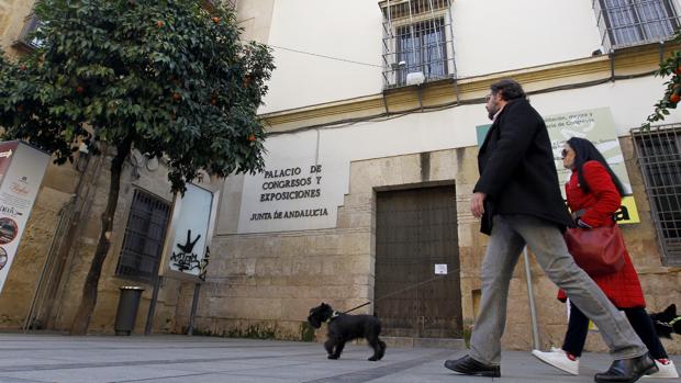 Dos personas cruzan delante de un cerrado Palacio de Congresos