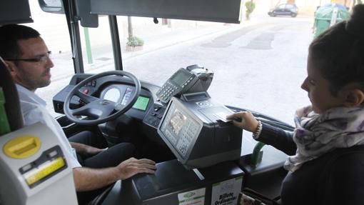 Una joven pasa su tarjeta para acceder a un autobús de Aucorsa