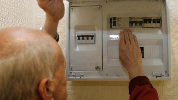 Un hombre manipula un contador eléctrico