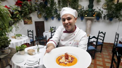 Un empleado del establecimiento con un plato de salmorejo