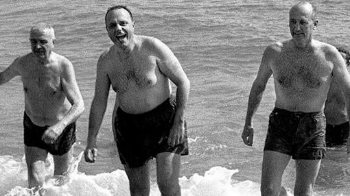 Foto de archivo del 8 de marzo de 1966 del ministro de Información y Turismo, Manuel Fraga (en el centro, y el embajador de Estados Unidos en España, Angier Biddle Duke (derecha), bañándose en la playa de Palomares