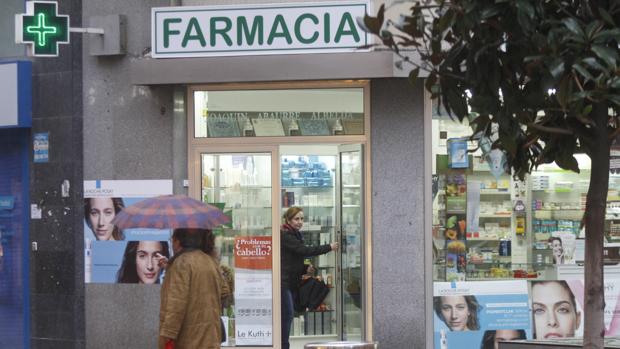 Una mujer sale del interior de una farmacia en el Centro de Córdoba