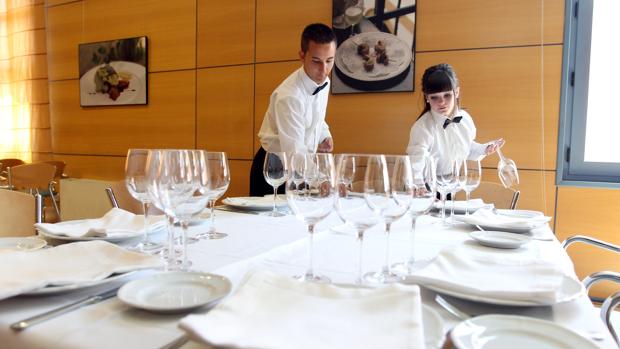 Dos alumnos de la Escuela de Hostelería de Córdoba preparan una mesa