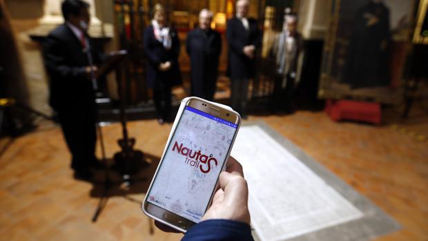 Un usuario muestra la app «Nautas Trail» en la capilla de las Ánimas