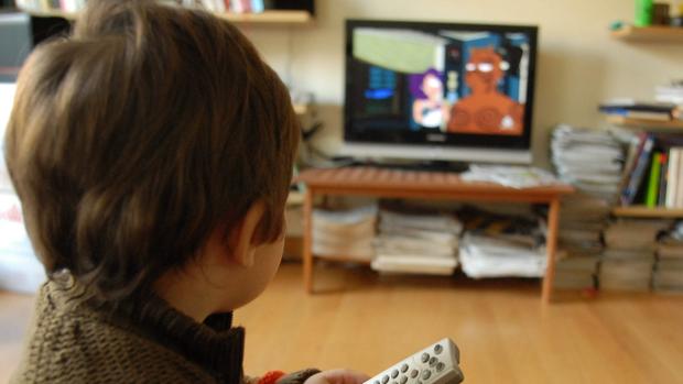 Un niño ve la televisión en el salón de una casa