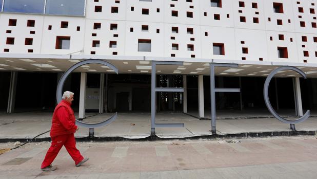 Un trabajador de UCOP pasa por delante de la obra del Centro de Ferias y Convenciones