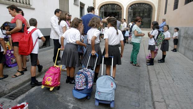 Un grupo de niños llegan al colegio en el primer día de clase