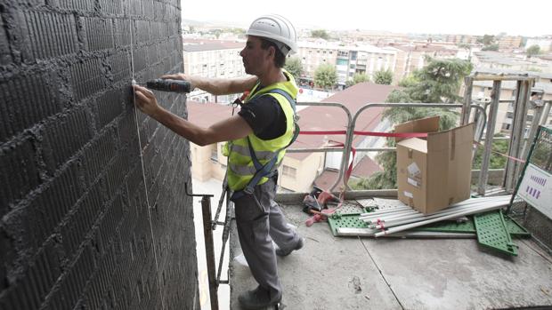 Un operario remata detalles en la fachada de la Normal