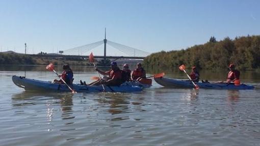 Familias disfrutando de una ruta en piragua por el Guadalquivir.