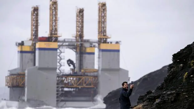 Un hombre se hace un selfi ante la gabarra que ha encallado frente a la costa de Benalmádena