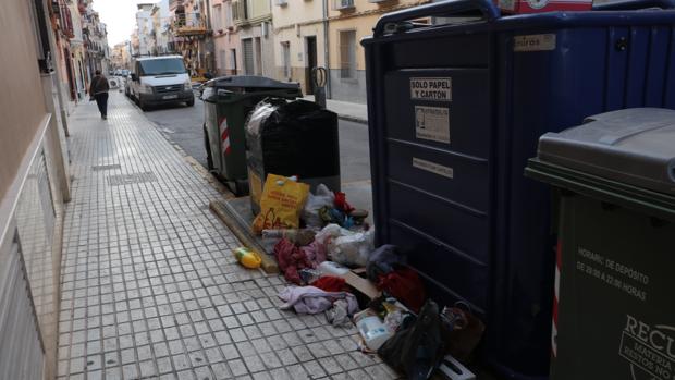 Bolsas de basura abandonadas junto a contenedores