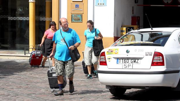 Unos turistas abandonan con sus maletas un hotel de la capital