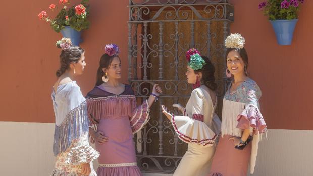 Un grupo de chicas vestidas de gitana a las puertas de una caseta