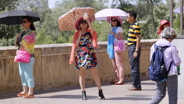 Turistas japonesas se protegen del calor con paraguas