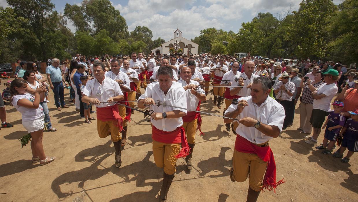 Los «danzaores» salen de la ermita bailando con sus espadas y San Benito cierra la procesión