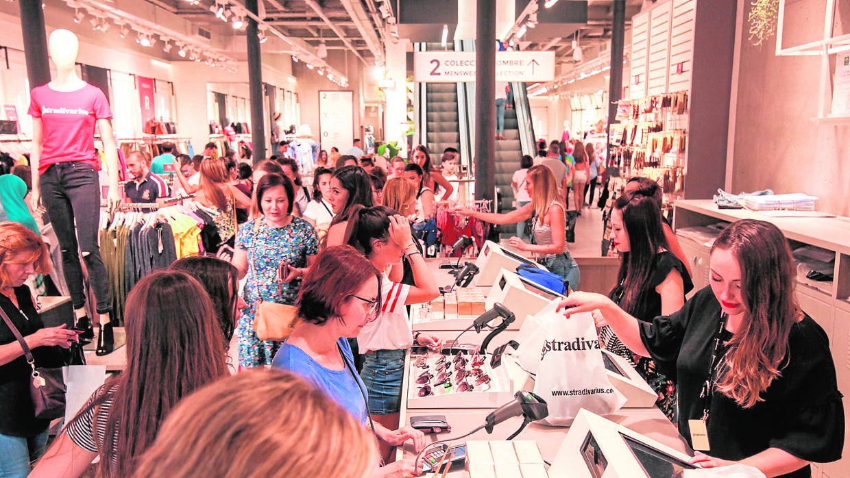 Varias personas en una tienda textil al comienzo de las rebajas