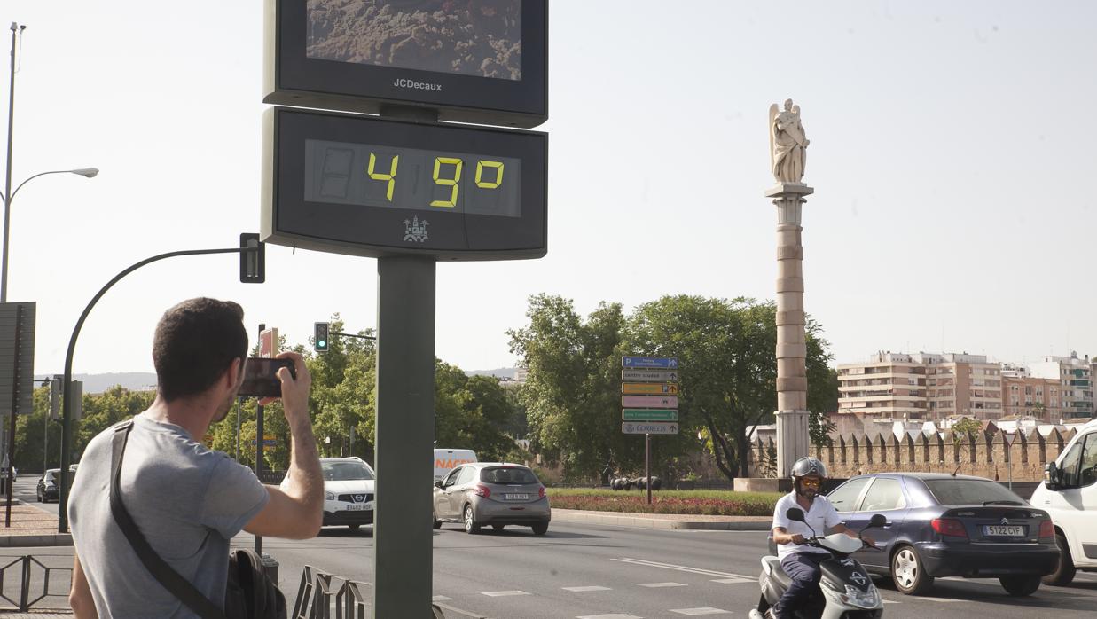 Un viandante realiza una fotografía a uno de los termómetros de la ciudad ubicado al sol