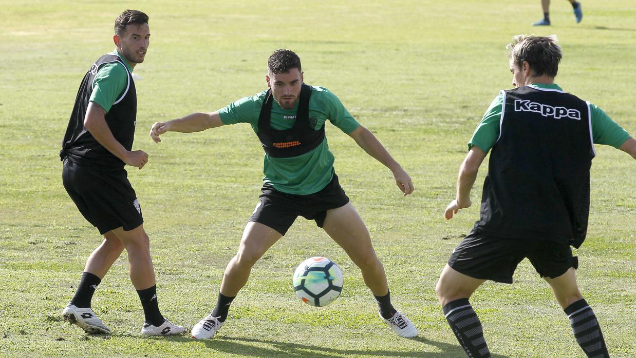 Javi Galán controla el esférico entre Fernández y Javi Lara