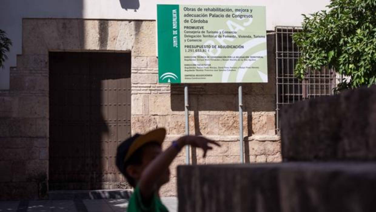 Un niño delante de la puerta principal del edificio de la calle Torrijos