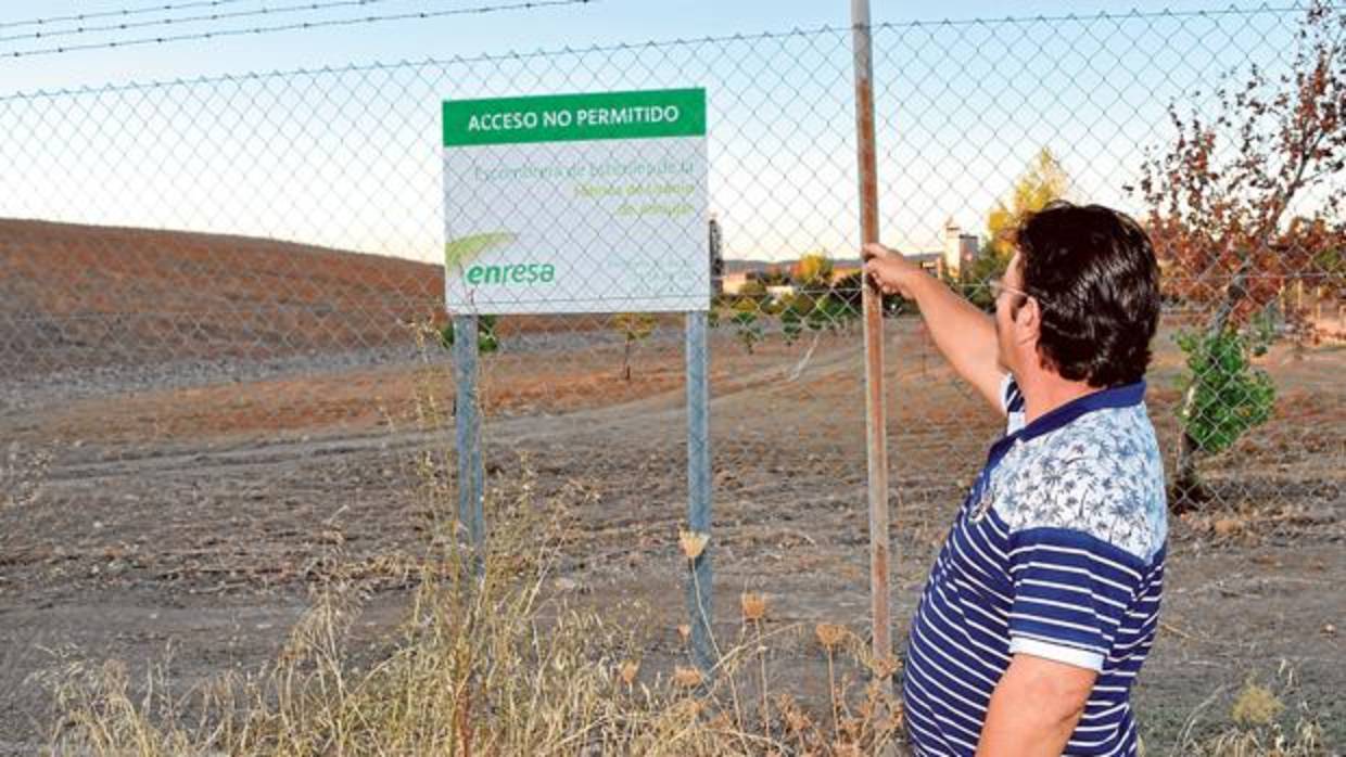 Un vecino señala el cartel del depíosito de uranio