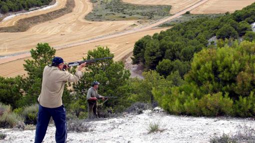 Dos hombres en una cima apuntan a una presa