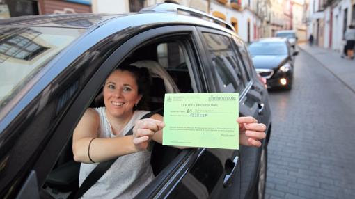 Una mujer muestra la tarjeta que le permite acceder al Centro