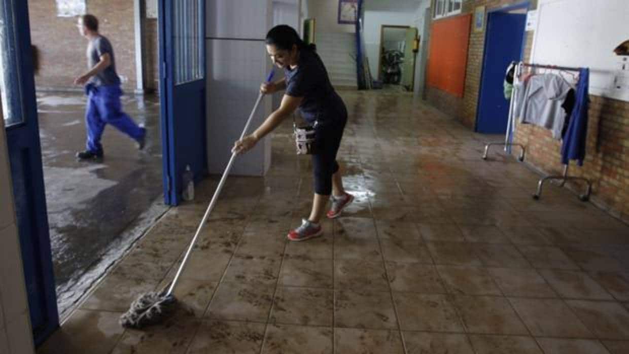 Una mujer limpia el barro en unas viviendas de la barriada de La Asunción de Jerez de la Frontera