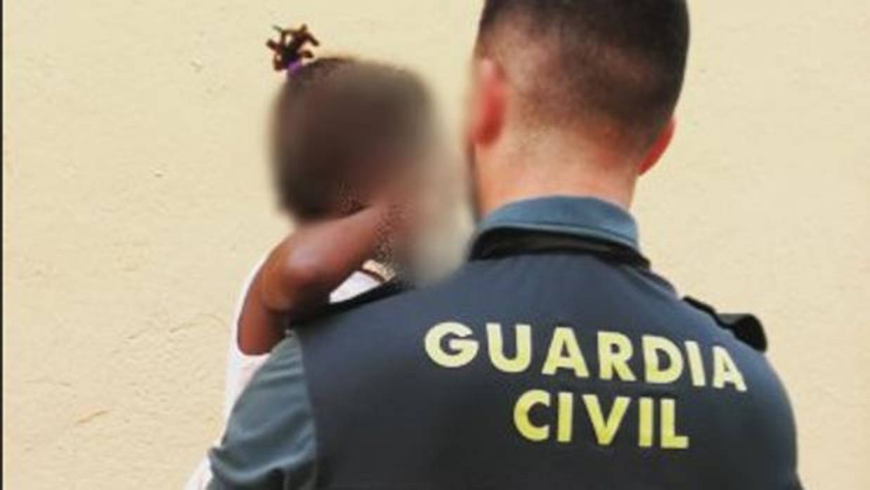 Un agente de la Guardia Civil con la pequeña en brazos