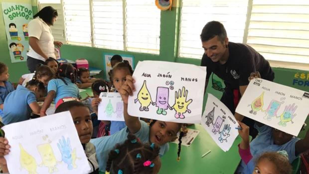 Antonio Caballero rodeado de niños en un colegio de la República Dominicana