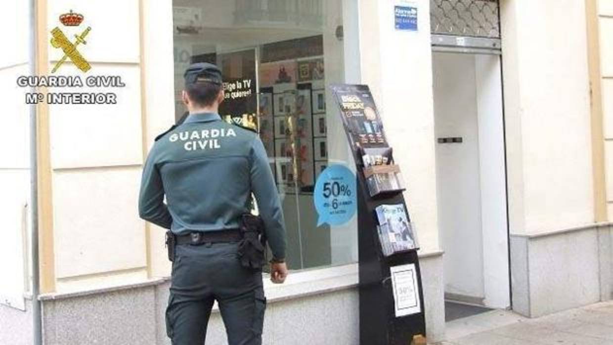Un agente de la Guardia Civil en una tienda de telefonía