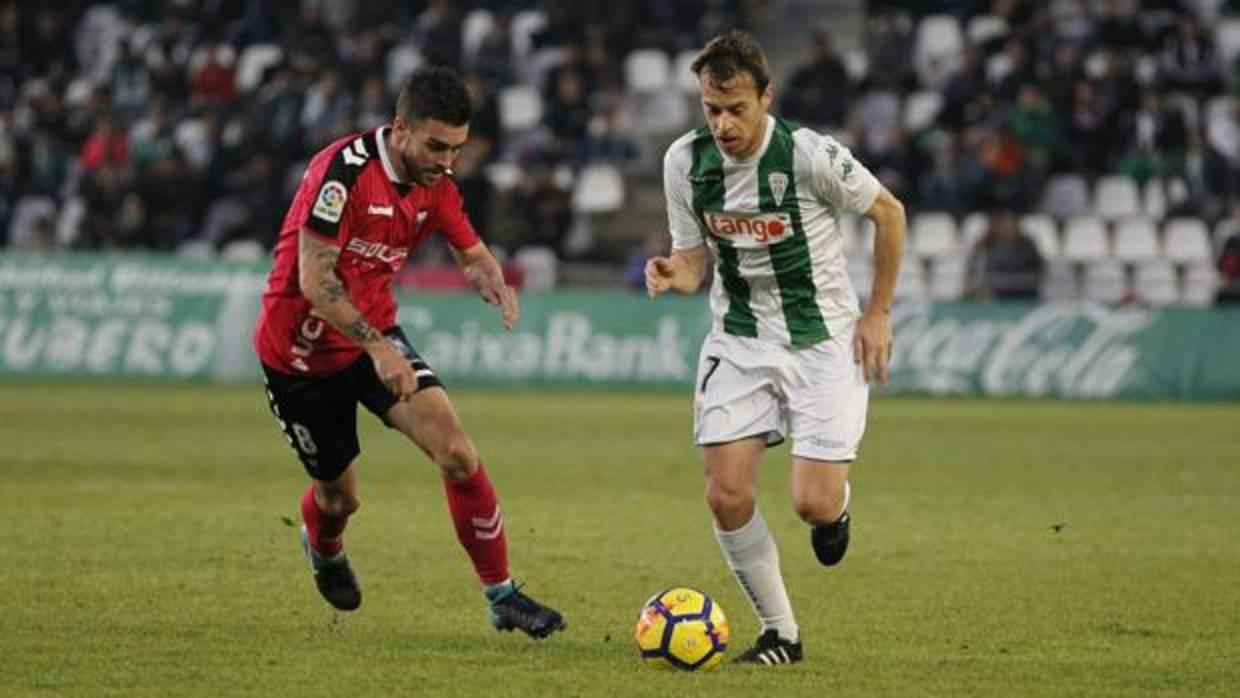 Javi Lara conduce ante la presión de Dani Rodríguez en el Córdoba CF-Albacete