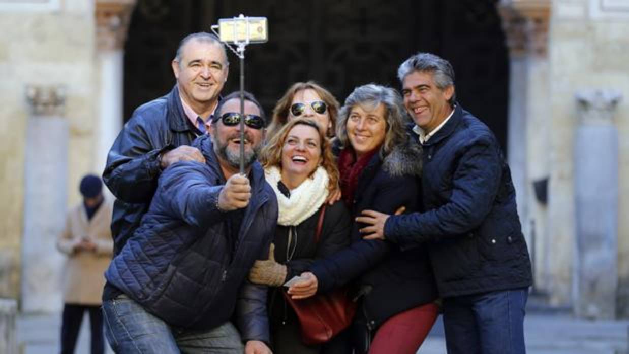 Un grupo de turistas se hace un selfie en el Patio de los Naranjos de la Mezquita-Catedral