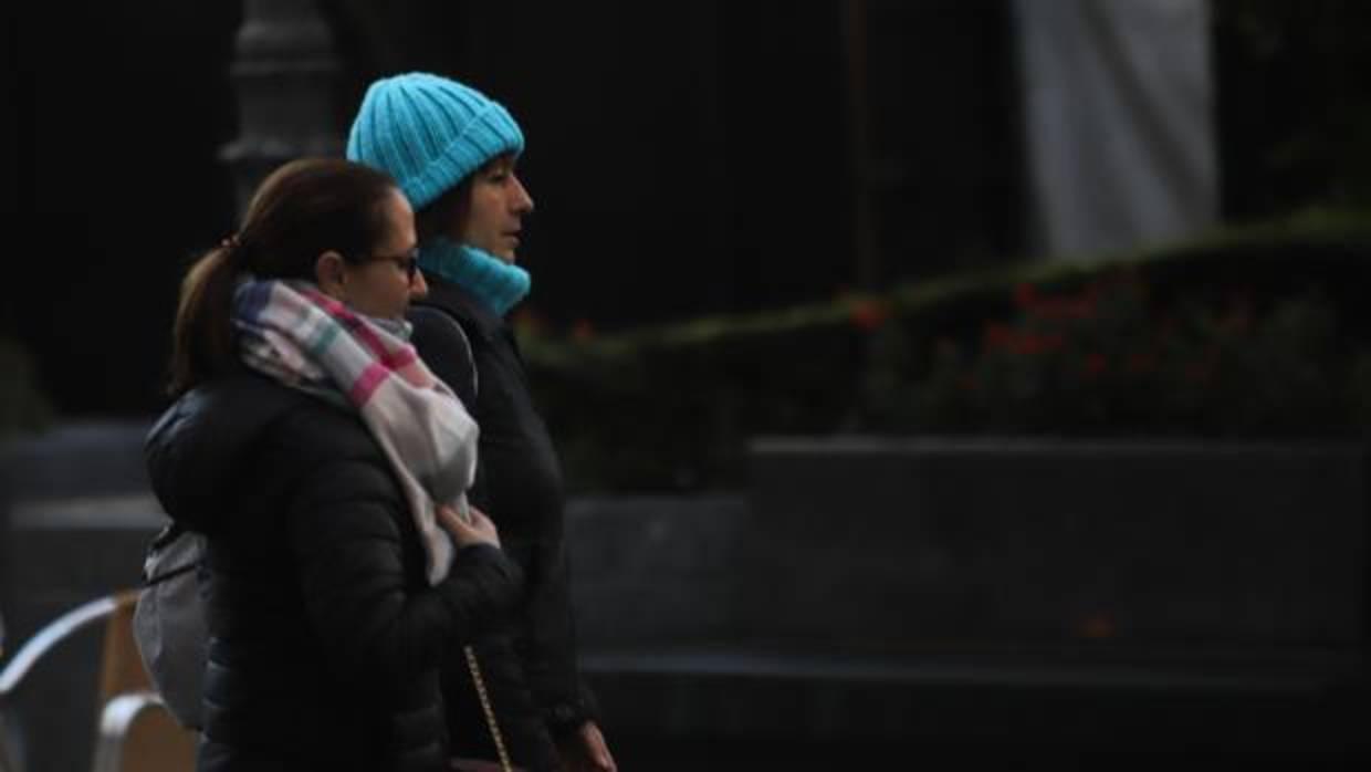 Dos personas caminan por el centro de Córdoba abrigadas contra el frío
