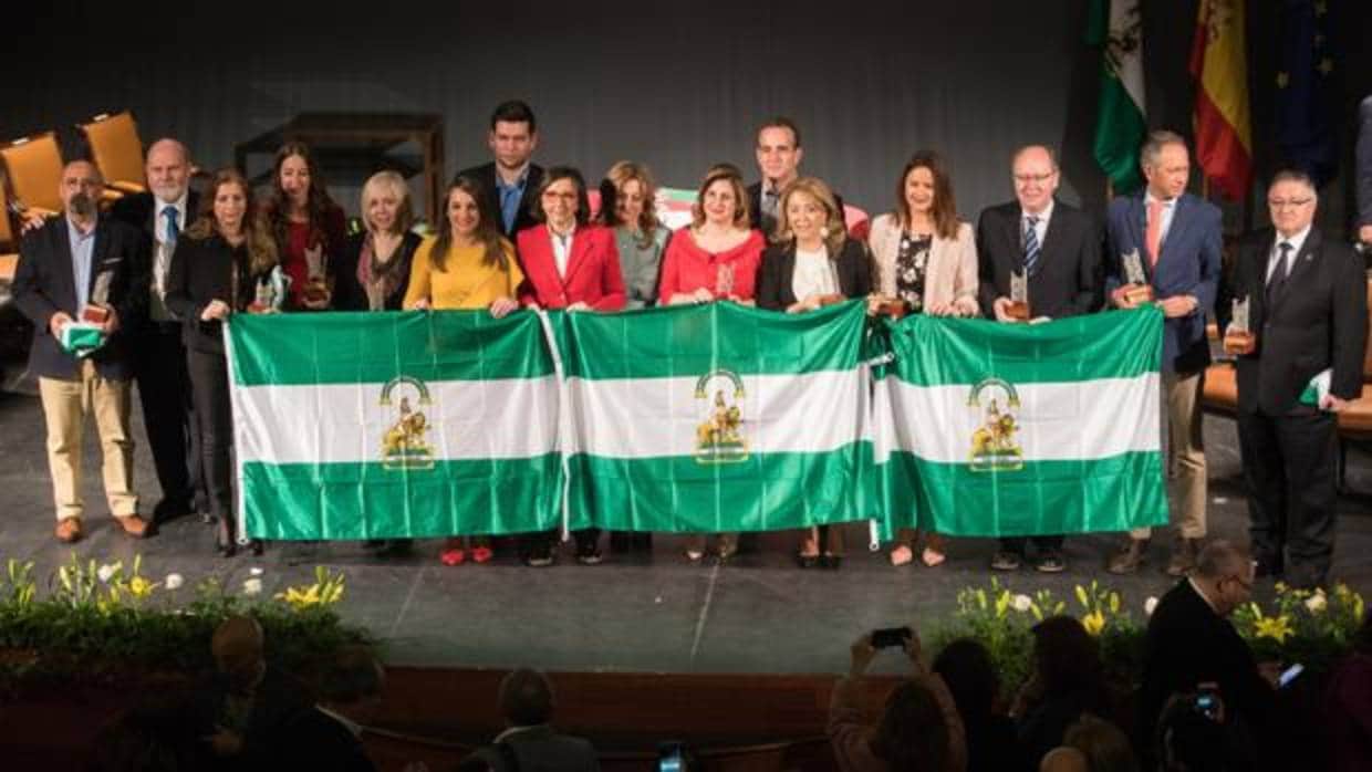Foto de familia de los distinguidos con la bandera de Andalucía