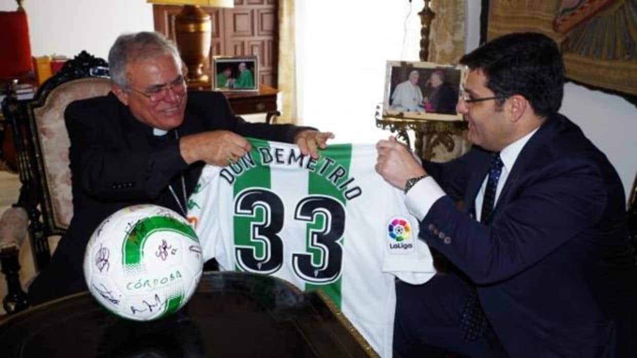 El presidente del Córdoba CF, Jesús León, entrega una camiseta al Obispo de Córdoba, Demetrio Fernández