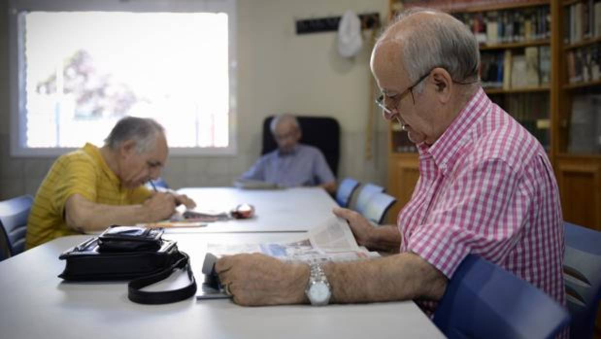 Imagen de un jublado leyendo prensa en una biblioteca