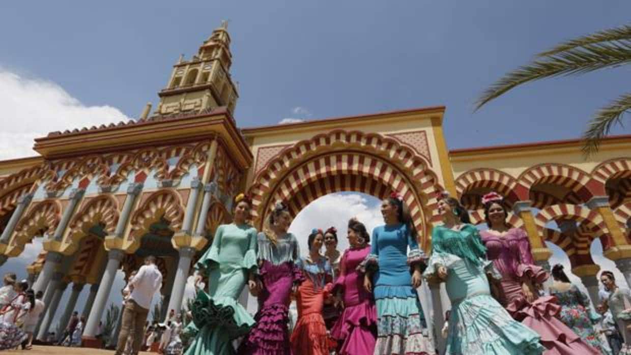 Un grupo de flamencas bajo un cielo limpio en la portada de la Feria