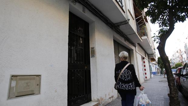 Una mujer pasa por delante del portal de la vivienda en la que sucedieron los hechos