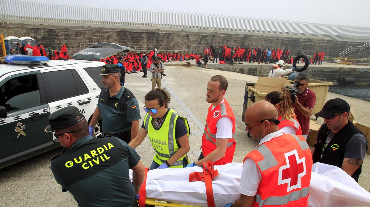 Efectivos de la Guardia Civil y Cruz Roja trasladan uno de los cuerpos rescatados en el mar