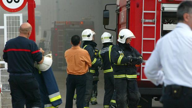 Los bomberos liberan el brazo a un trabajador de una máquina en la fábrica de Biomass Center en Alcolea