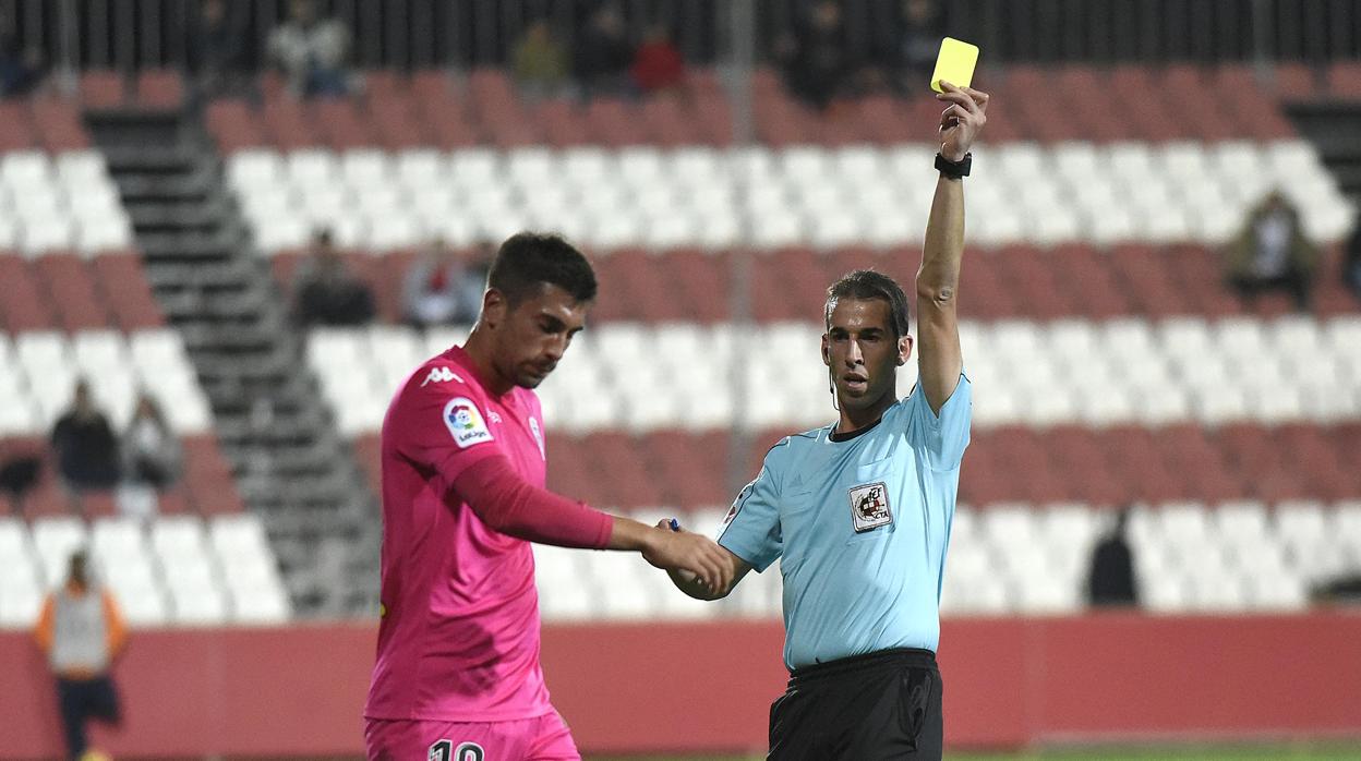 El gallego Pérez Pallas muestra la amarilla a Josema en el duelo ante el Sevilla Atlético