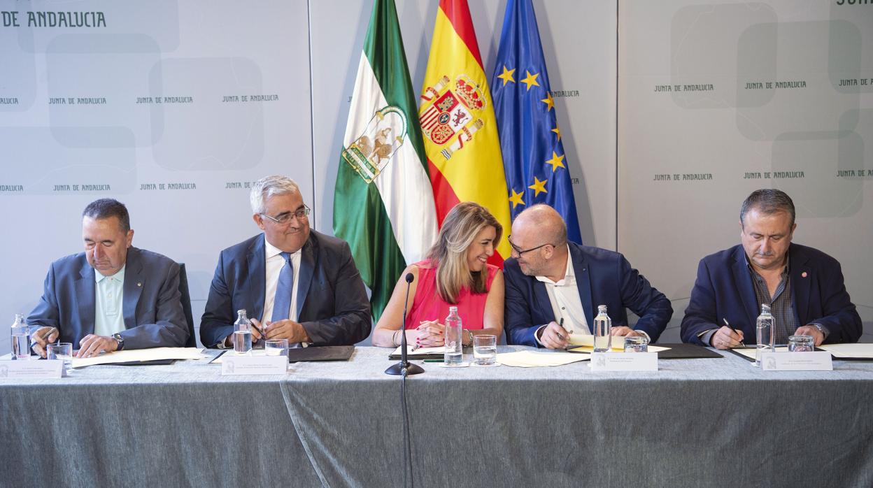 Susana Díaz, en el centro, durante la firma del acuerdo con los sindicatos