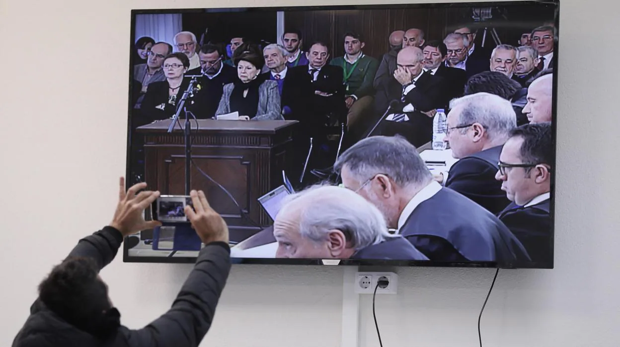 Un periodista fotografía el monitor de la sala de prensa en la Audiencia de Sevilla en el juicio de los 22 exaltos cargos de la Junta
