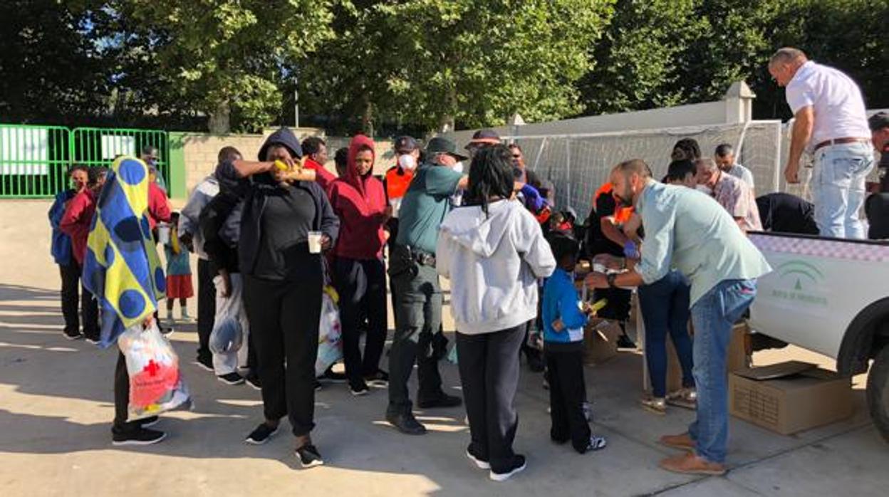 Voluntarios sirven el desayuno a los inmigrantes alojados en el polideportivo de Los Barrios este verano